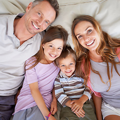 Image showing Love, portrait and happy family in bed for relax on holiday, vacation or hotel accommodation on weekend. Face, parents and children with smile, bonding and above in bedroom with healthy relationship