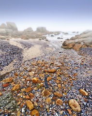 Image showing Beach, rocks and stone on sand in nature, landscape or environment with fog on sea or horizon. Offshore, ocean and travel on vacation or holiday to South Africa in summer to calm water or waves