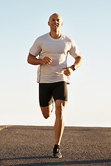 Image showing Man, running in street and fitness for cardio, health and fresh air when training for marathon with sky background. Sports, exercise and athlete in portrait for workout, wellness and endurance