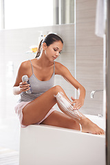 Image showing Skincare, foam and woman shaving legs in a bathroom for hair removal, hygiene or smooth skin in her home. Beauty, product and female person with gel, soap or bottle for cosmetic, wellness or routine