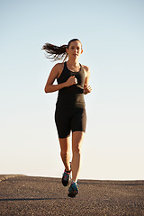 Image showing Woman, running in street and fitness for cardio, health and fresh air when training for marathon with sky background. Sports, exercise and athlete in city for workout, wellness and endurance