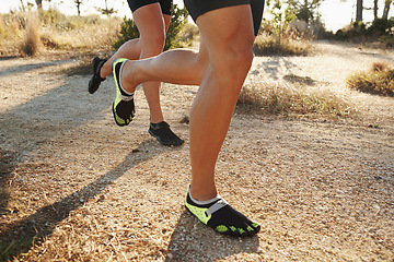 Image showing Closeup, people and legs with running footwear for fitness, exercise or outdoor training on dirt road. Person and runner with sports shoes for hiking, trekking or cardio workout together in nature