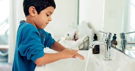 Image showing Young boy, washing hands and hygiene for health, sustainability and water at routine at home. Male child, bathroom and clean with soap, foam and sink in healthy with hand washing and disinfection