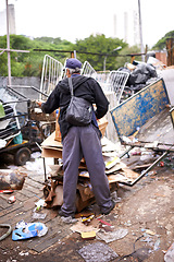 Image showing Man, worker and recycling of garbage for waste management in city with rear view, bag and scrapyard. Person, back and search by dumpster site for scrap, rubbish and trash in neighborhood for litter