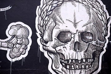 Image showing Graffiti, painting and wall mural in neighborhood with skull illustration and creativity in the city. Urban, art and black and white on a street with drawing in Sao Paulo outdoor with design tag