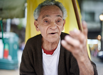 Image showing Conversation, city and senior man talking in a neighborhood outdoor with chat and communication. Urban, sitting and Asian male person with wisdom, street and road with travel and advice with gesture