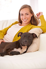 Image showing Woman, dog and relax in living room in portrait, smile for pet love and bonding at home with domestic canine. Happy, positive and trust with foster or adoption, pitbull puppy and animal care on couch