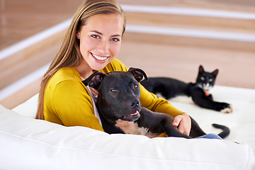 Image showing Woman, pets and relax on sofa in portrait, smile for dog and cat love with bonding at home. Happy, positive and trust with foster or adoption, cuddle puppy in living room and domestic animal care