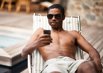 Image showing Happy man, browse and relax on deckchair, phone and scroll on social media on summer holiday. Black male person, smile and online for blog or app for chat on travel to Nigeria, vacation and outdoors