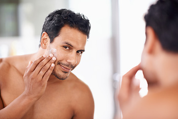 Image showing Skincare, mirror and cream with man in bathroom for morning routine, facial treatment and cosmetics. Self care, confidence and face of male person for sunscreen, lotion or moisturizer in reflection.