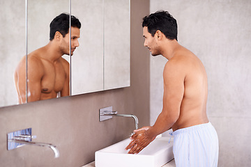 Image showing Washing, skincare and mirror with man in bathroom for facial treatment, bacteria and hygiene. Healthy skin, dermatology and male person for grooming, wellness and morning routine in reflection.