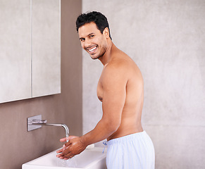 Image showing Portrait, skincare and water with man in bathroom for washing hands, bacteria and facial hygiene. Healthy skin, dermatology and face of male person for grooming, wellness and morning routine.