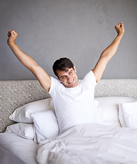 Image showing Man, morning and stretch in bed, yawn and smile for daily routine and house for rest and wellness. Male person, happy and bedroom in pajamas, and home in waking up and relaxing on Saturday day off