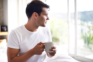 Image showing Man, coffee and bed with window for morning, wakeup, daydream or thinking with sunlight and caffeine. Young and male person with looking and relax for ponder, thought idea indoor for weekend