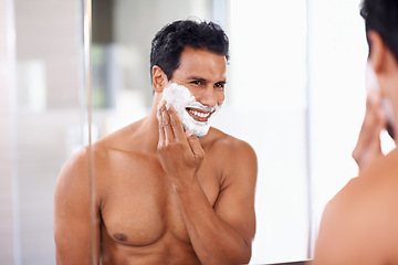 Image showing Man, skincare and foam on face in bathroom mirror for shaving, grooming and hair removal. Smile, cosmetics and happy male person for wellness, facial treatment or morning routine with reflection.