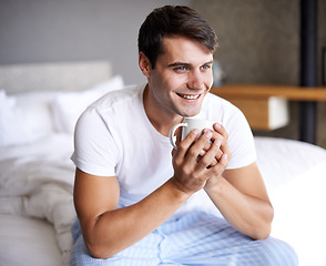 Image showing Man, bedroom and morning coffee sitting and thinking, weekend off in apartment to relax with attractive male person. Casual and holiday or home, Saturday off day and comfortable positive guy with cup