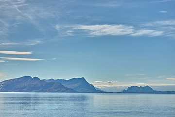 Image showing Ocean, blue sky and mountains in nature for travel, tourism destination or vacation with landscape background. Sea, surface and water reflection by island for eco friendly adventure and Norway mockup