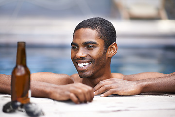 Image showing Man, beer and relax poolside, happy and swimming on weekend for wellness on summer holiday. Black male person, luxury hotel and calm or peace on travel to Nigeria, vacation and alcohol outdoors