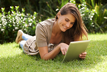 Image showing Tablet, happiness and woman outdoor on grass, nature and garden for communication, technology and internet. Gen z female person, backyard and digital pad for social media, connectivity and browsing