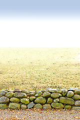 Image showing Landscape, land and wall with stone for agriculture in nature with mockup space, grass and natural environment in Amsterdam. Field, meadow and farmland for farming, conservation or sky in countryside