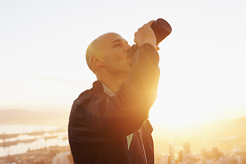 Image showing Man, fitness and drinking water with sunset for natural sustainability, break or outdoor hydration. Thirsty male person or athlete with liquid bottle after workout, exercise or training in nature