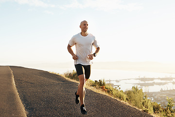 Image showing Fitness, running and man on road in mountain for health, wellness and strong body development. Workout, exercise and runner on path in nature for marathon training, performance and challenge on hill.