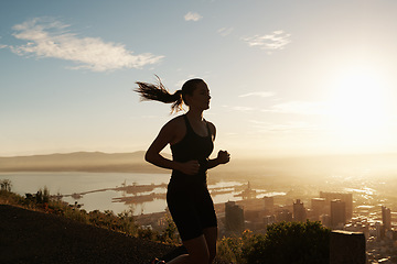 Image showing Fitness, running and woman on hill at sunset for health, wellness and strong body development. Workout, exercise and girl runner on path in nature for marathon training, performance and challenge.