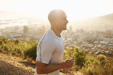 Image showing Fitness, running and man in mountain at sunset or health, wellness and strong body development. Workout, exercise and happy runner on path in nature for marathon training, performance and challenge.