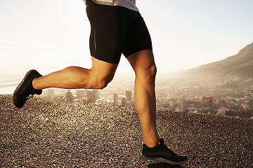 Image showing Legs, sneakers and person running in city street, cardio and fitness for health and wellness at sunrise. Athlete, speed and runner on outdoor road for exercise, workout and training in morning