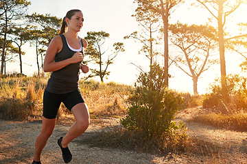 Image showing Fitness, running and woman on path in nature for health, wellness and strong body development. Workout, exercise and girl runner on road in woods for marathon training, performance and challenge.