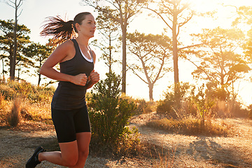 Image showing Fitness, running and woman in nature at sunrise for health, wellness and strong body development. Workout, exercise and girl runner on path in woods for marathon training, performance and challenge.