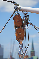 Image showing Closeup, pulley and hook with rope on ship, dock or harbor with transport and navigation for sailing. Yacht, cruise with journey or travel, cable and chain for nautical vessel, equipment and rigging