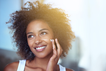 Image showing African woman, skin and cream in bathroom for beauty, wellness and afro in home to start morning routine. Girl, person and serum for cosmetics, change and transformation with facial glow in apartment