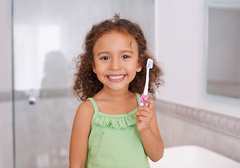 Image showing Portrait, smile and girl brushing teeth in a bathroom for dental, wellness or oral care in her home. Happy, face and kid in a house with toothbrush for mouth cleaning, child development or learning