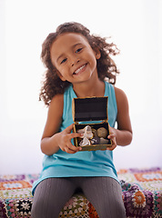 Image showing Happy, portrait and girl with gift on a bed for birthday, surprise or good job, reward or present in her home. Face, smile and kid with jewellery box in bedroom for seashells, collection or hobby