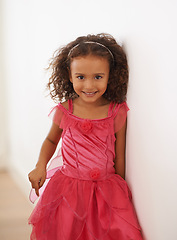 Image showing Girl, child and portrait or smile in fashion with confidence, wellness and headband for fairy aesthetic in home. Kid, face and happiness with relax by wall in living room with dress and curly hair