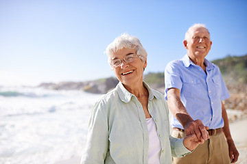 Image showing Elderly, couple and walk on beach for portrait on retirement vacation or anniversary to relax with love, care and commitment with support. Senior man, woman and together by ocean for peace on holiday