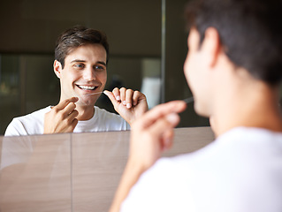 Image showing Happy man, teeth and dental care with floss for hygiene, grooming or freshness in bathroom mirror at home. Face of handsome male person with smile in routine for oral, mouth or gum cleaning at house