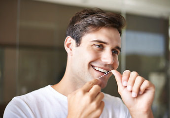 Image showing Happy man, flossing and teeth with dental care for hygiene, grooming or freshness in bathroom at home. Face of handsome male person with smile in routine for oral, mouth or gum cleaning at the house