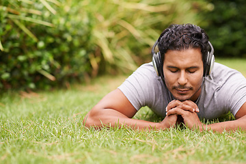 Image showing Man, outdoor and headphones on grass, peace and meditating outside for wellness in nature. Male person, backyard and tech to relax, listen and vacation at home or house for peace in music or podcast