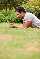 Image showing Man, outdoor and tablet on grass, browse and watching social media or memes for entertainment in nature. Male person, backyard and tech to relax, scroll and vacation at home or house for peace