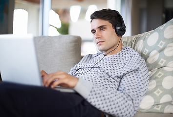 Image showing Research, headphones or man on laptop for streaming movies, music or film series in home to relax. Podcast, radio or person on sofa listening online on technology for digital blog or playlist on web
