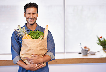 Image showing Groceries, bag and portrait of man with healthy food in kitchen for nutrition, diet or cooking in home. Happy, customer and vegan person with a smile for fruits, vegetables and fresh bread in house