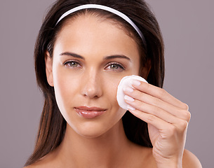 Image showing Beauty, cotton pad and woman with makeup removal in portrait, hygiene and skincare with wellness on grey background. Wipe, cosmetic product and dermatology for healthy skin and glow in studio