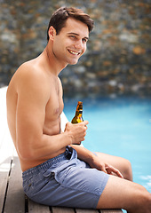 Image showing Man, enjoy and happy by swimming pool with beer to relax or chill on summer vacation, luxury and resort or villa. Male person, bottle and alcohol for refreshments on tropical holiday in Maldives.