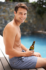 Image showing Man, relax and happy by swimming pool with beer to drink or chill on summer vacation, luxury and resort or villa. Male person, bottle and alcohol for refreshments on tropical holiday in Maldives.