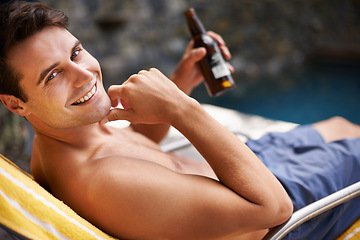 Image showing Portrait, man and relax by swimming pool with beer to drink or chill on summer vacation, luxury and resort or villa. Male person, bottle and alcohol for refreshments on tropical holiday in Maldives.