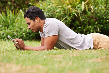 Image showing Man, outside and tablet on grass, browse and watching social media or memes for entertainment in nature. Male person, backyard and tech to relax, scroll and vacation at home or house for peace