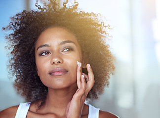 Image showing African woman, skincare and cream in bathroom for beauty, wellness and afro in home to start morning routine. Girl, person and serum for cosmetics, change and transformation with face in apartment