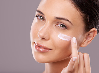 Image showing Portrait, cream and woman with skincare, dermatology and wellness on grey studio background. Face, person and model with lotion and shine with creme and beauty with moisturise, smile or aesthetic